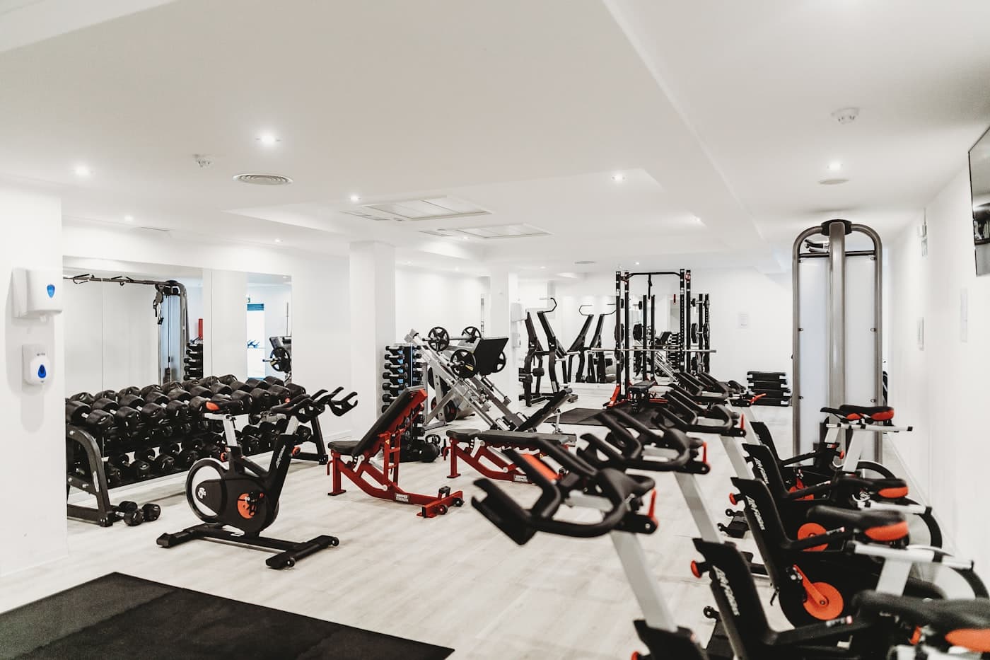 Man training with kettlebells in a bright, modern gym