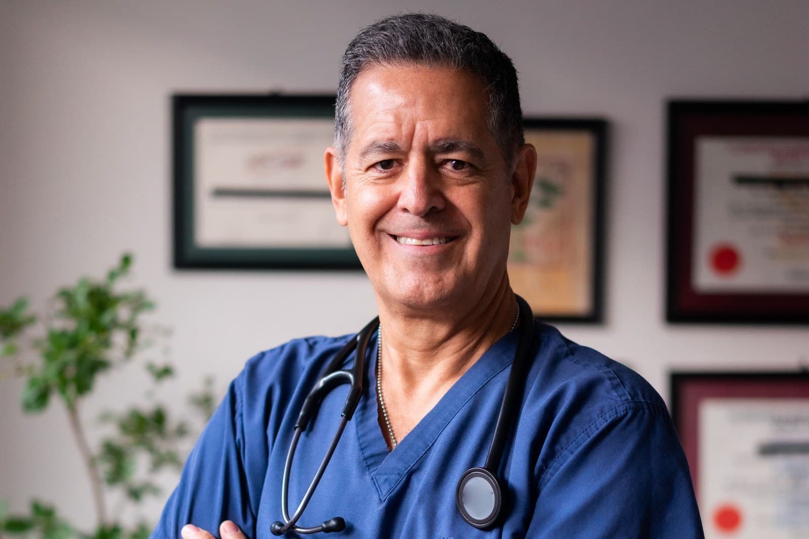 Clinician in scrubs with a stethoscope in a medical office